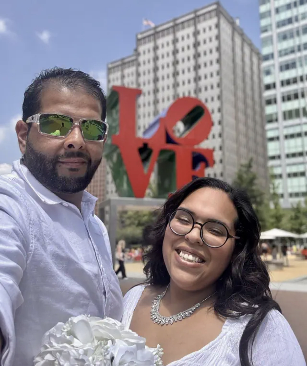 Jocelyn and her husband smiling in front of the LOVE sculpture in Philadelphia