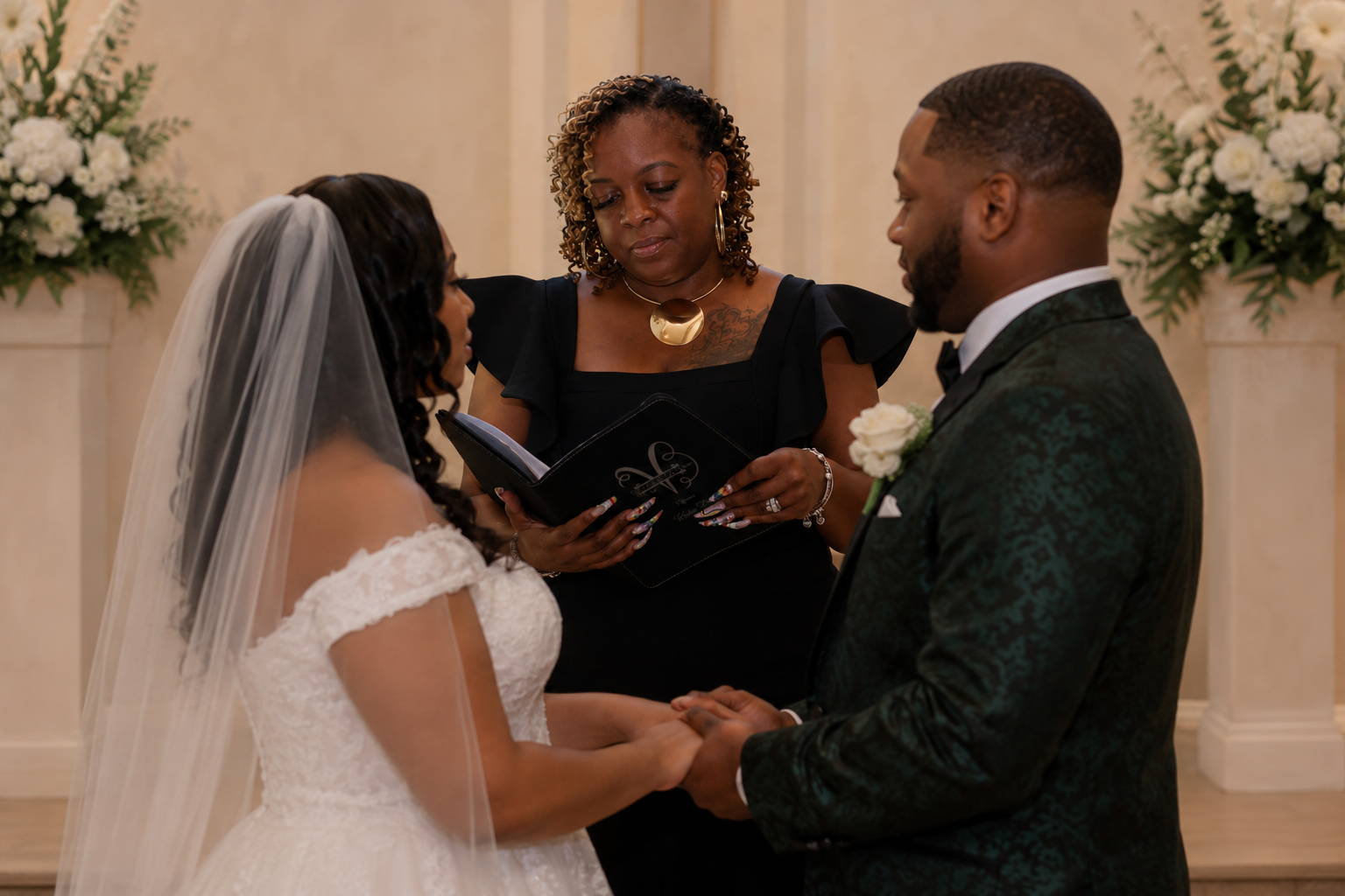 Kesha leading a couple through their vows at an indoor ceremony